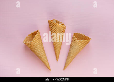 Drei leere Waffel Kegel auf einem rosa Hintergrund. Flach. Minimalismus. Stockfoto