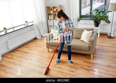 Asiatische Frau mit Besen fegen und Reinigung Stockfoto
