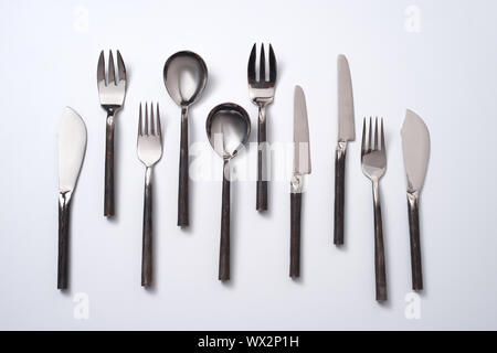 Satz von Vintage metall Löffel, Gabeln und Messer auf einem grauen Hintergrund mit Platz für Text. Flach Stockfoto
