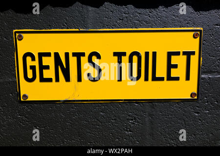 Gelb Herren wc Schild auf Schwarz bemalte Wand. Stockfoto