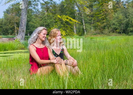 Zwei junge Frauen sitzen zusammen in der Natur Stockfoto