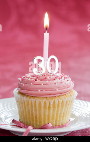 Mini dreißigsten Geburtstag Kuchen mit einer einzigen Kerze dekoriert Stockfoto