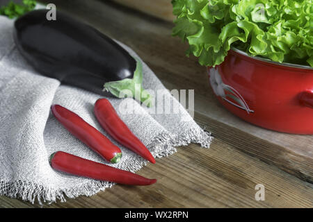 Grüner Salat, Auberginen und Paprika auf einen hölzernen Tisch. Stockfoto