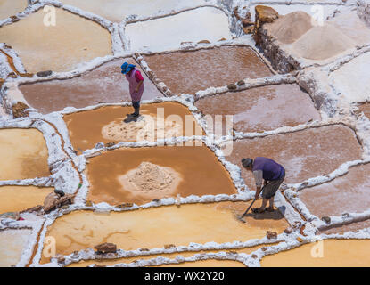 SALINAS DE MARAS, PERU - 12. Oktober 2015: Arbeitnehmer, die Gewinnung von Salz in Salinas de Maras, in der Nähe von vom Menschen verursachten Salzminen Cusco, Peru Stockfoto