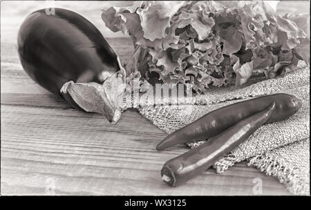 Grüner Salat, Auberginen und Paprika auf einen hölzernen Tisch, schwarz-weiß-Bild. Stockfoto