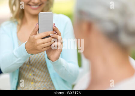 Tochter fotografieren senior Mutter von Smartphone Stockfoto