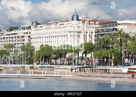 Promenade Cannes mit unbekannten Menschen und eine Vorderansicht des berühmten Carlton Hotel in Cannes, Frankreich Stockfoto