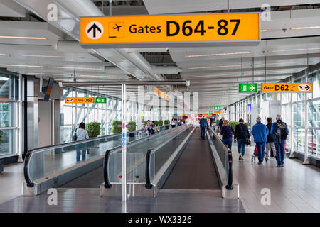 Die Reisenden zu Fuß zum Gate am Flughafen Schiphol, Niederlande Stockfoto