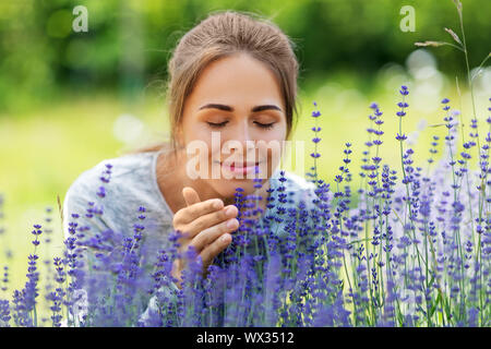 Junge Frau duftenden Lavendel Blumen im Garten Stockfoto