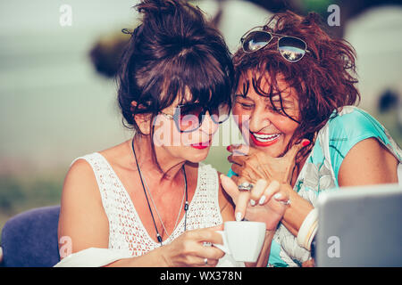Nahaufnahme, Porträt von zwei älteren Frauen gerne lachen und Spaß beim Trinken von Kaffee in einem Café im Freien. Stockfoto