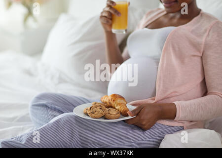 Schwangere Frau, Frühstück im Bett, zu Hause Stockfoto