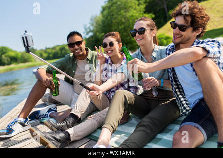 Freunde mit Getränken unter selfie auf See Pier Stockfoto