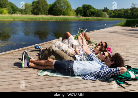 Freunde trinken Bier und Apfelwein vom See Pier Stockfoto