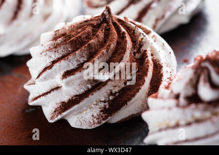 Weiß Baiser mit Kakao Pulver Stockfoto
