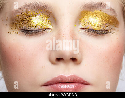 Nahaufnahme Makroaufnahme von geschlossenen menschlichen weiblichen Gesicht mit gelben rauchigen Augen Beauty Makeup. Stockfoto