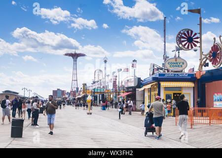 Coney Island, USA - 14. Juni 2019: Iconic Boardwalk mit Fallschirm und Coney Kegel stehen Stockfoto