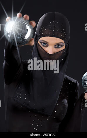 Partei-Tänzerin in Ninja-Kleid mit Disco-Kugeln Stockfoto