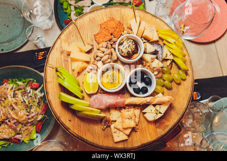 Italienische Antipasti Wein Snacks. Brushettas, Käse, mediterrane Oliven, Gurken, Prosciutto di Parma mit Melone, Salami und Wein im Glas Stockfoto