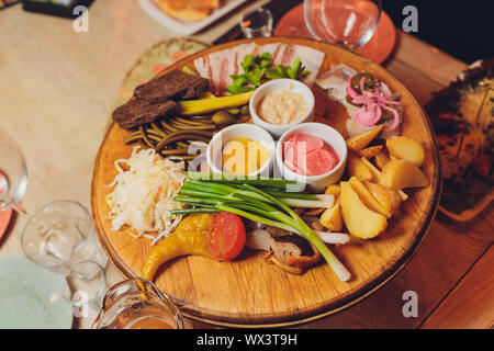 Italienische Antipasti Wein Snacks. Brushettas, Käse, mediterrane Oliven, Gurken, Prosciutto di Parma mit Melone, Salami und Wein im Glas Stockfoto