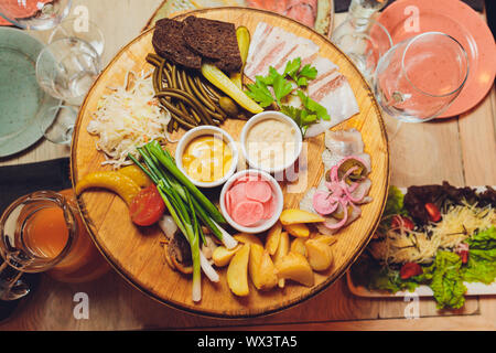 Italienische Antipasti Wein Snacks. Brushettas, Käse, mediterrane Oliven, Gurken, Prosciutto di Parma mit Melone, Salami und Wein im Glas Stockfoto