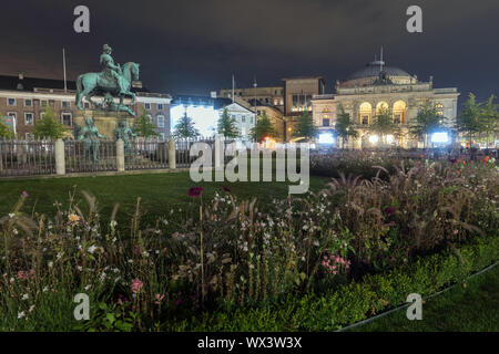 Kongens Nytorv durch die Nacht, in Kopenhagen, Dänemark, mit dem Reiterstandbild von Christian V und dem Königlichen Theater, rechts Stockfoto