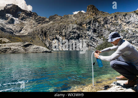 Bergsteiger Pumpen und Filtern Trinkwasser aus einem See in den Anden von Peru Stockfoto