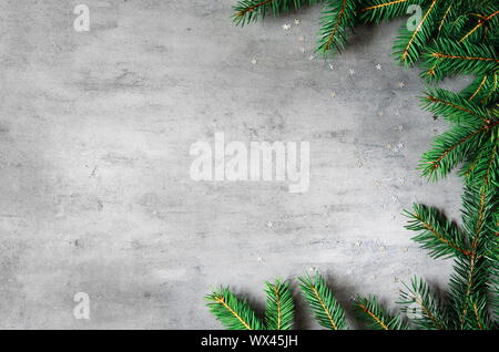 Tannenzweigen Grenze auf grauem Hintergrund, Weihnachten Kulisse. Stockfoto