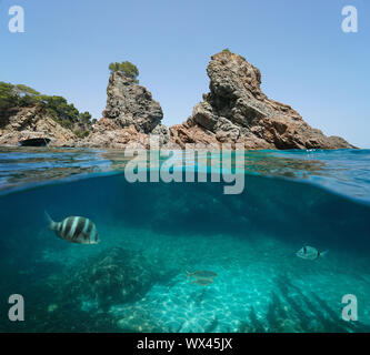 Felsigen kleinen Inseln mit einigen Fischen unter Wasser, Mittelmeer, Spanien, Costa Brava, Katalonien, Calella de Palafrugell, geteilte Ansicht Hälfte über und unter Wasser Stockfoto