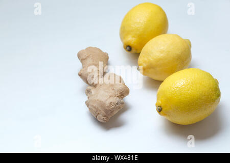 Drei gelbe Zitronen und ginger root auf einem hellen Hintergrund. Stockfoto