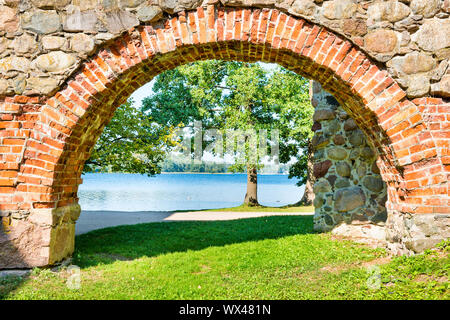 Brick arch und Baum in der Nähe des Sees Stockfoto