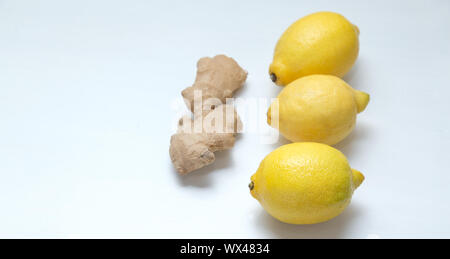 Drei gelbe Zitronen und ginger root auf einem hellen Hintergrund. Stockfoto