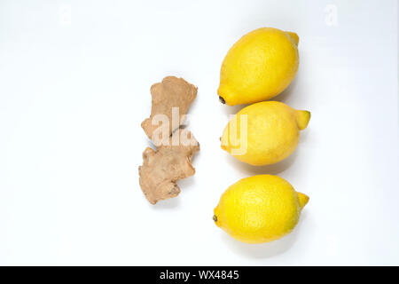 Drei gelbe Zitronen und ginger root auf einem hellen Hintergrund. Stockfoto