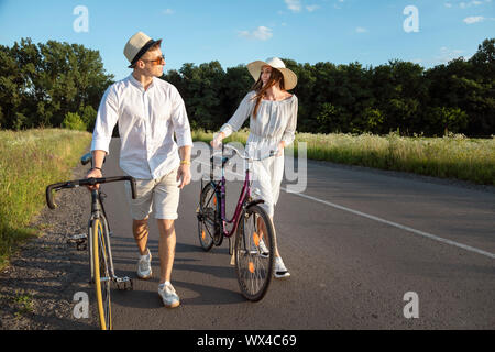 Paar Fahrrad mitreisenden Chatten in einer sonnigen Landschaft Straße Stockfoto