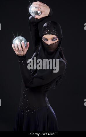 Partei-Tänzerin in Ninja-Kleid mit Disco-Kugeln Stockfoto