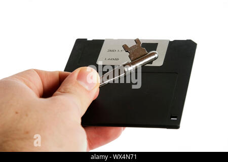 Eine 3 1/2" Diskette in der Hand eines Mannes mit einem Skelett Taste gehalten wird. Auf weiß mit Freistellungspfad isoliert. Stockfoto