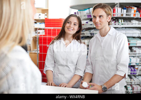 Zwei Apotheker an Kunden in der Apotheke Stockfoto