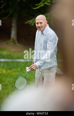 Portrait von reifer Mann in Freizeitkleidung mit Schläger und Birdie bereit zu dienen Stockfoto