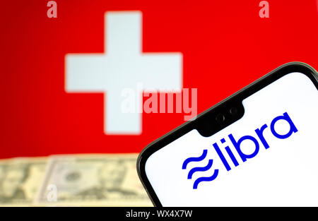 Facebook Waage Logo auf dem Bildschirm des Smartphones mit Dollar Noten und die Flagge der Schweiz bei unscharfer Hintergrund. Konzept Foto. Stockfoto