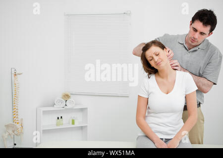 Arzt untersucht den Hals seines Patienten stehen in einem Arztzimmer Stockfoto