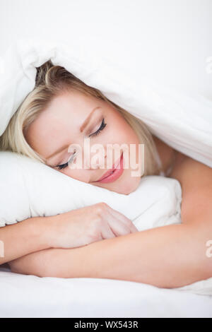 Blondine, friedlich schlafend in ihrem Bett Stockfoto