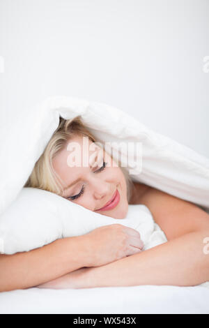Junge Frau friedlich schlafend in ihrem Bett Stockfoto