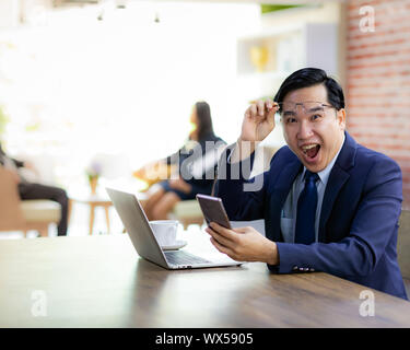 Asiatische Geschäftsmann Feiern im Cafe Stockfoto