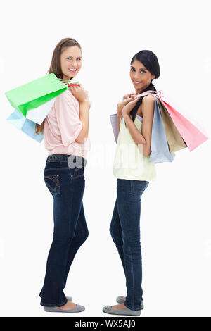 Lächelnde Frauen tragen eine Menge Einkaufstüten Stockfoto