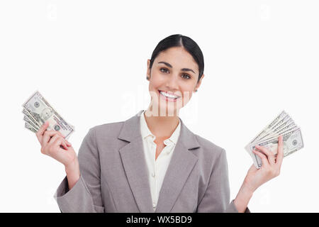 Lächelnde Verkäuferin mit Geld in ihre Hände vor einem weißen Hintergrund Stockfoto