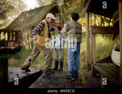 Vater sieht seiner zwei Kinder angeln. Stockfoto
