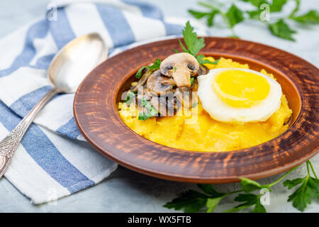 Polenta mit karamellisierten Pilze, Ei und Petersilie. Stockfoto