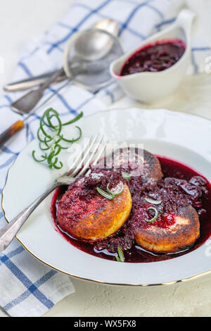 Quark Pfannkuchen mit kirschsauce mit Rosmarin. Stockfoto