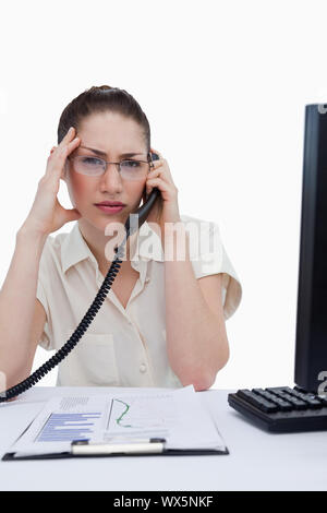 Porträt einer müde Manager einen Anruf bei Statistiken vor einem weißen Hintergrund suchen Stockfoto