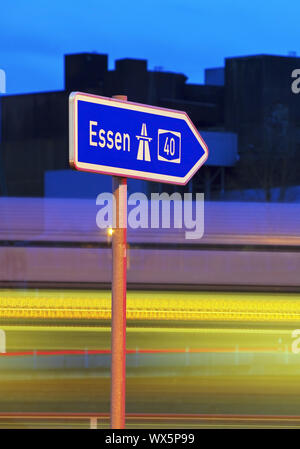 Hinweisschild nach Essen auf der Autobahn A 40 am Abend, Bochum, Ruhrgebiet, Deutschland, Europa Stockfoto
