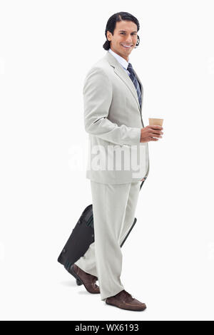 Seitenansicht der Geschäftsmann mit Kaffee und wheely Bag vor einem weißen Hintergrund Stockfoto